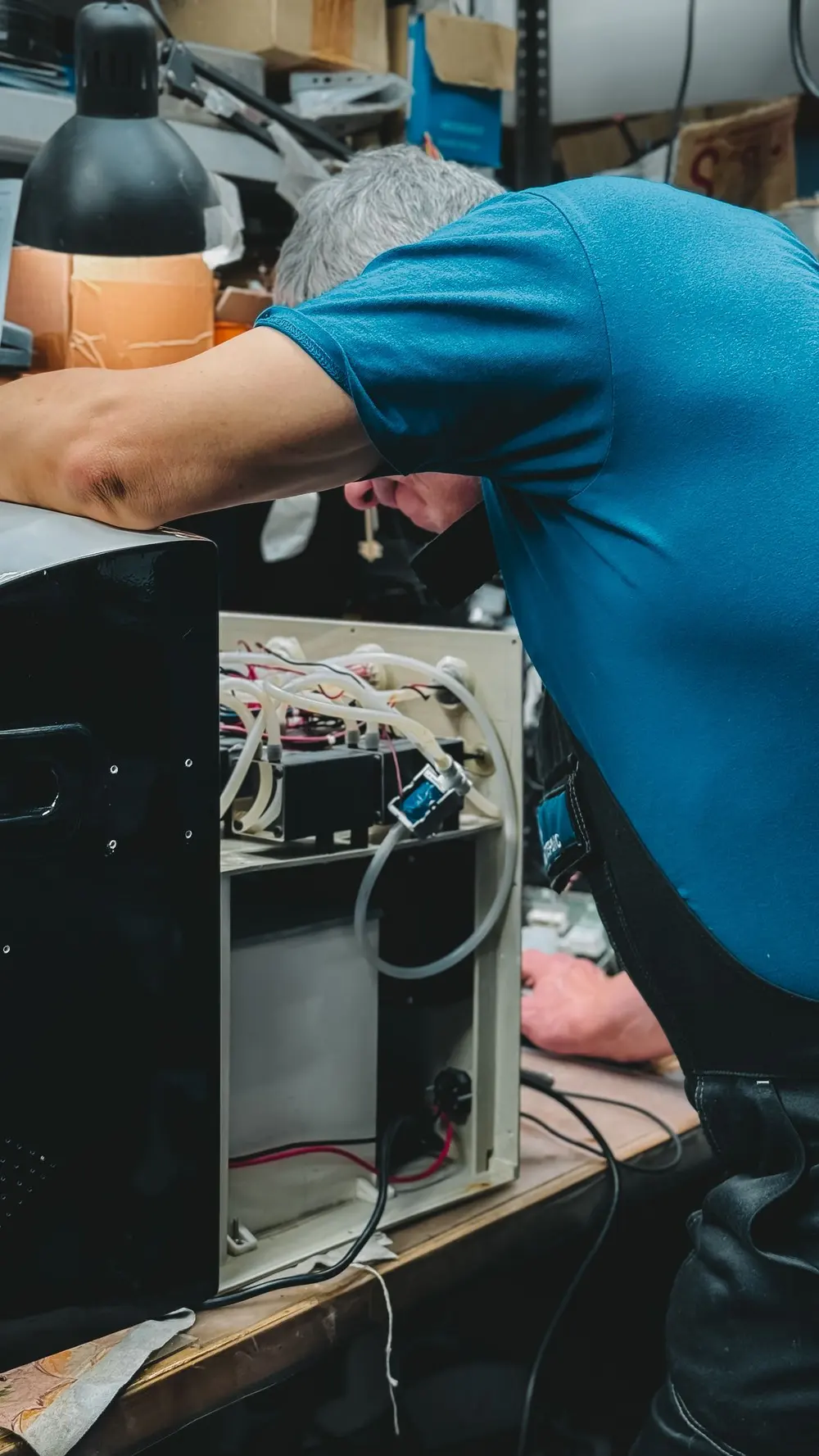 Technician repairing an appliance in a workshop